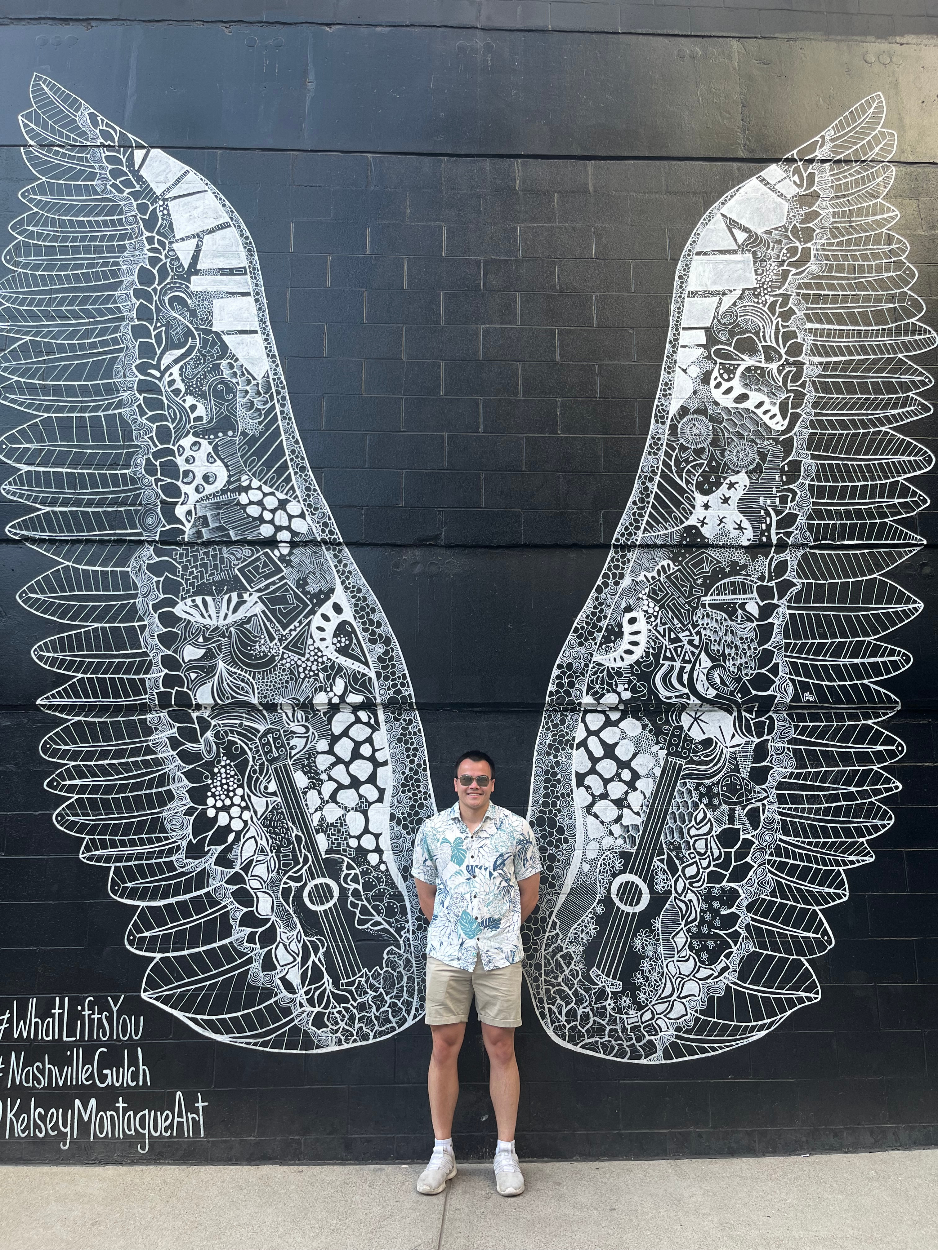Devin in front of butterfly mural